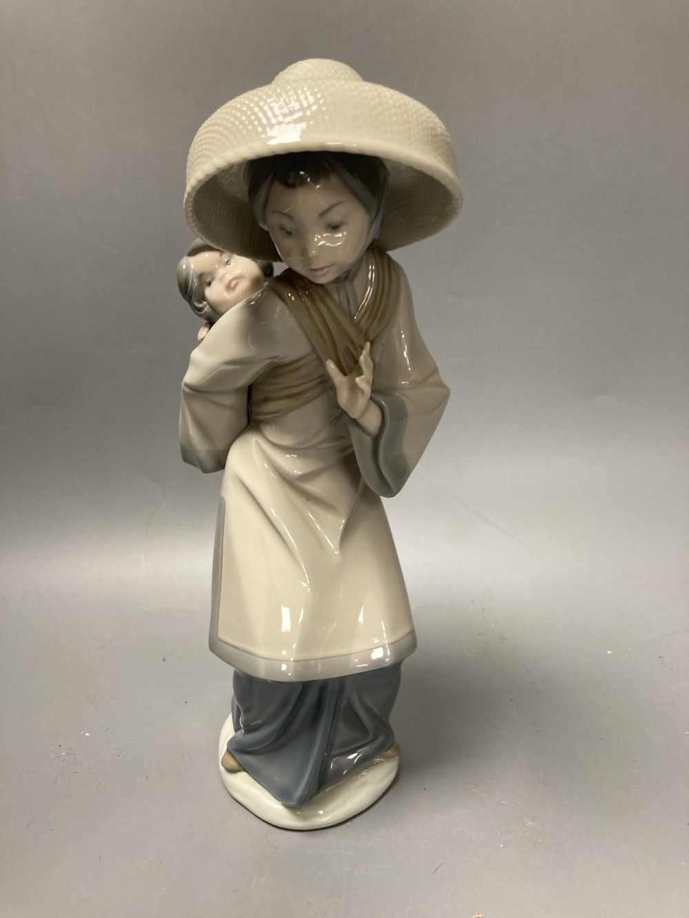 Two Lladro porcelain figures and a Royal Copenhagen model of a seal, tallest 26cm